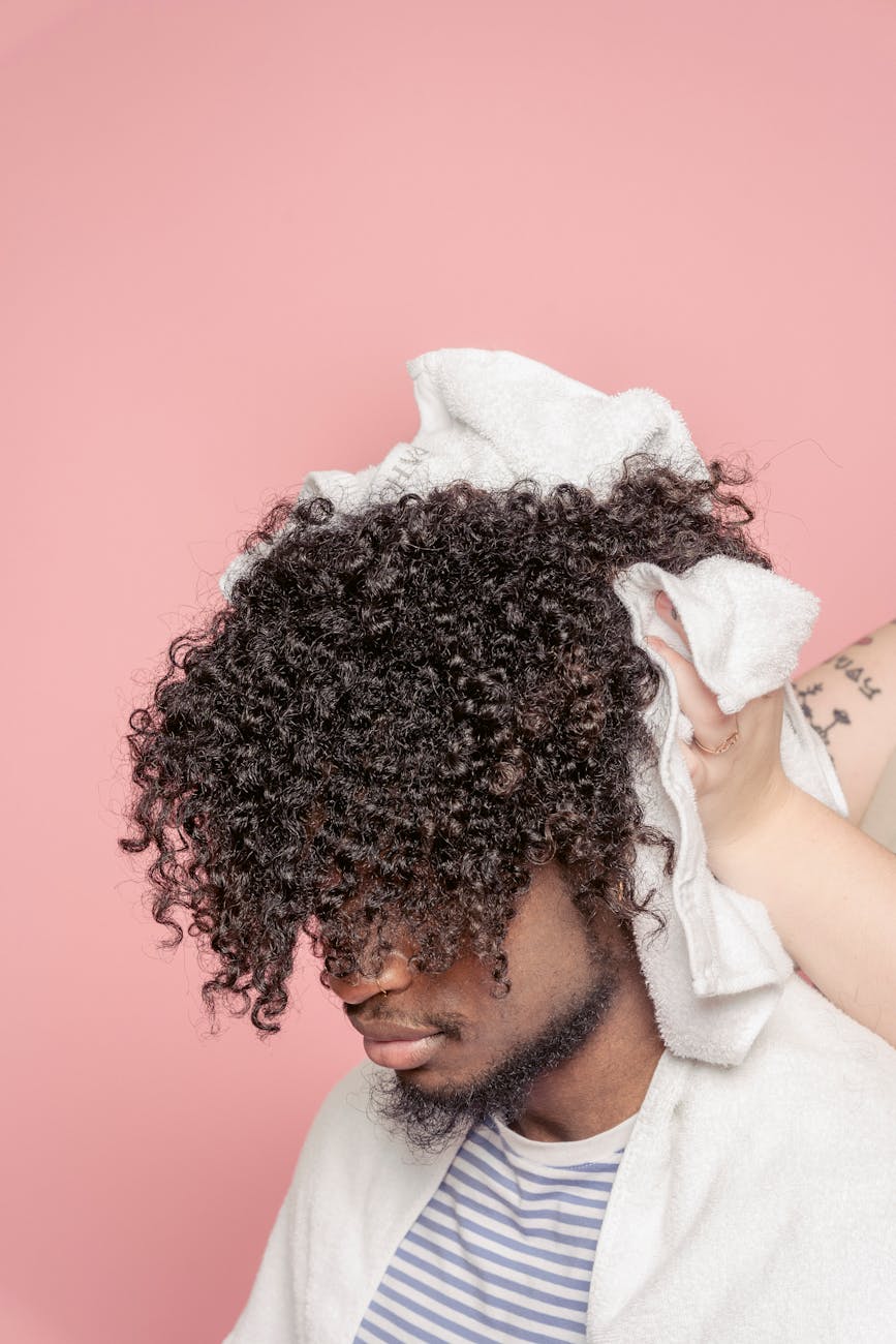 anonymous stylist drying hair of black client