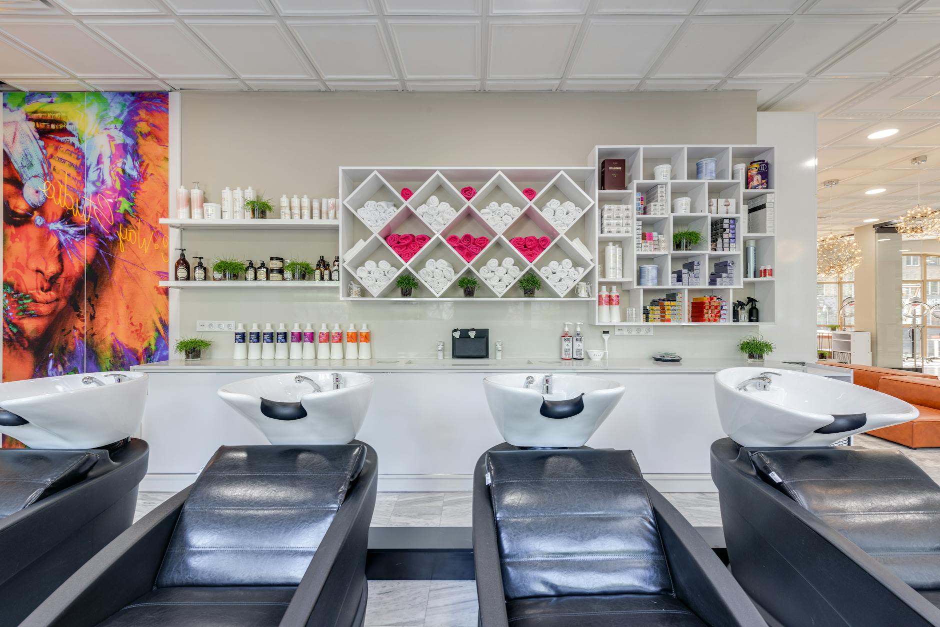 a row of black leather shampoo beds in a salon